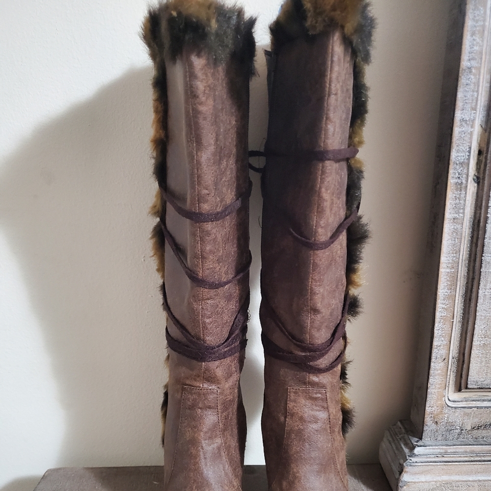 Brown knee high boot with a little fur.